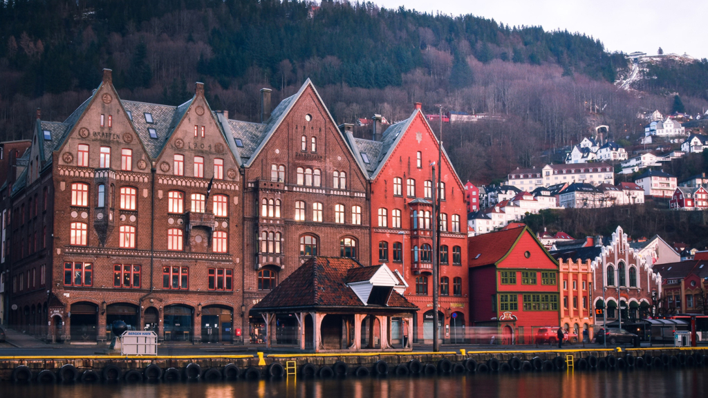 Evening light shining on a row of buildings along the water in Bergen, Norway.