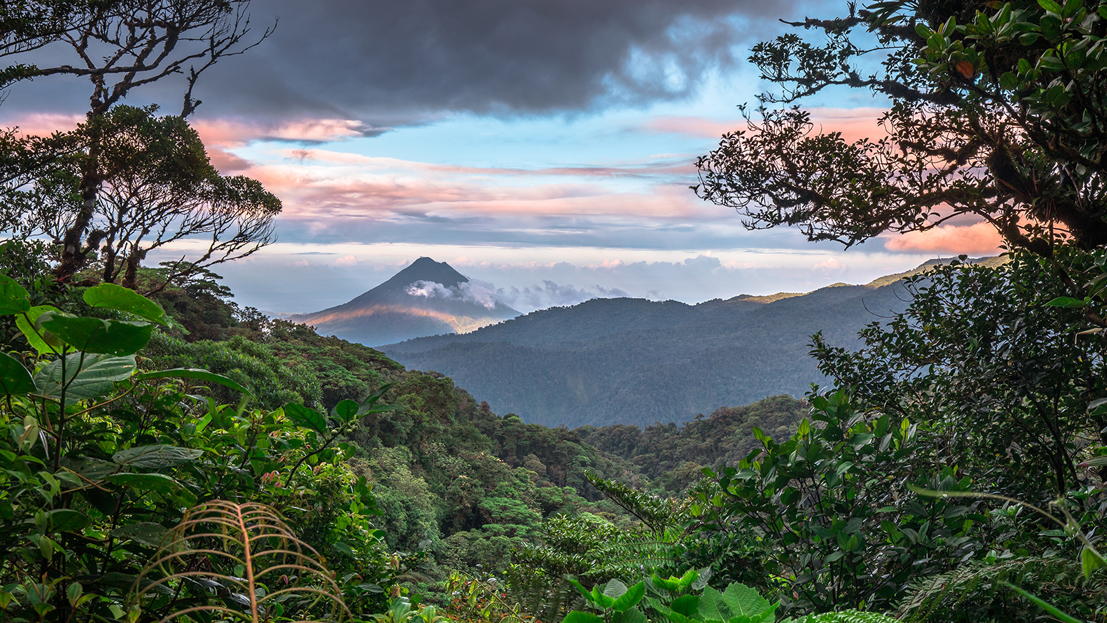 Volcan Arenal dominates the landscape during sunset, as seen from the Monteverde area, Costa Rica.