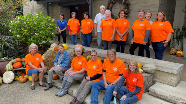 Group of adults outside wearing orange shirts.