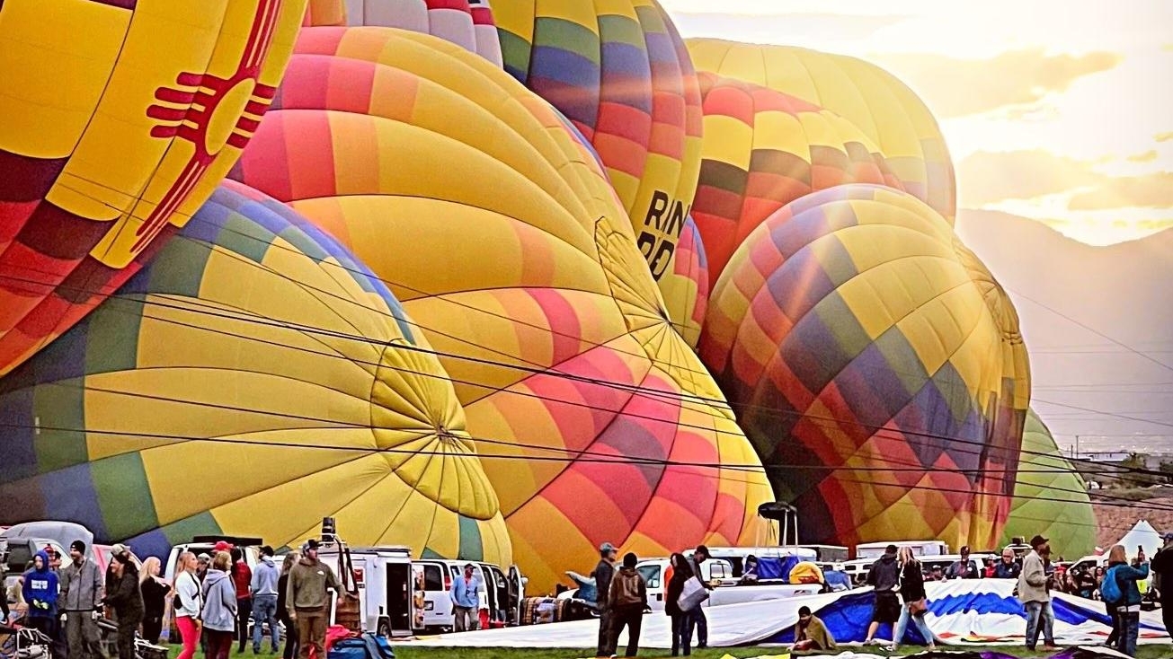 Colorful hot air balloons being inflated at the start of the Albuquerque International Balloon Festival