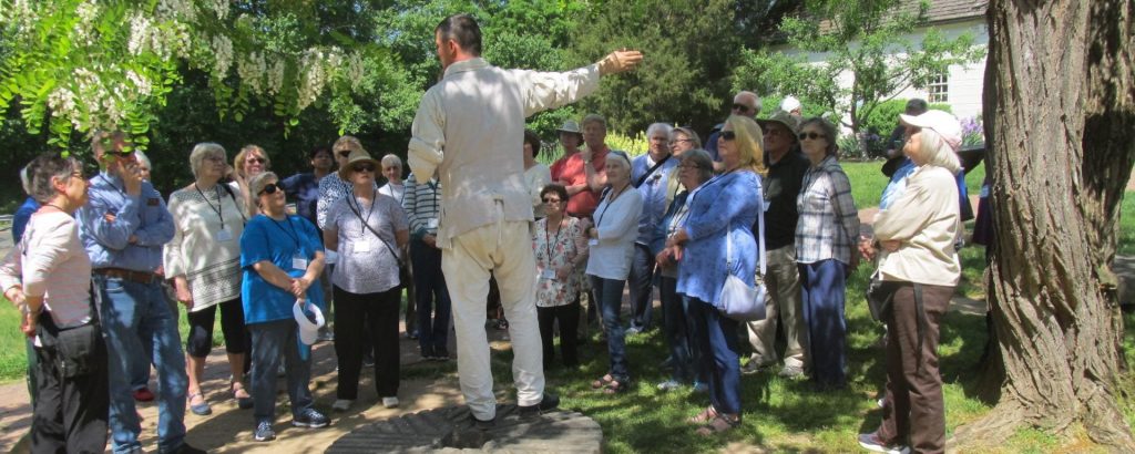 OLLI members standing outside listening to an instructor