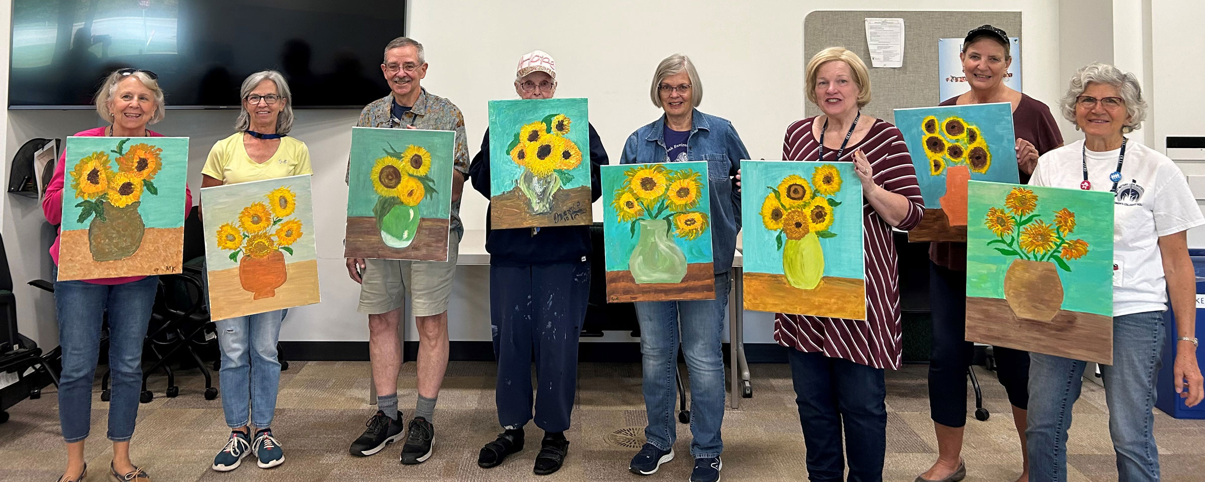 OLLI members holding their sunflower paintings
